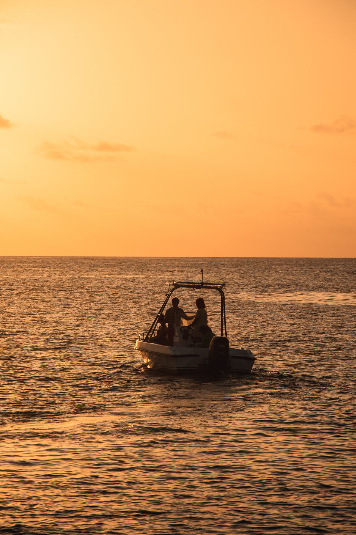 A small boat out on the water at sunset